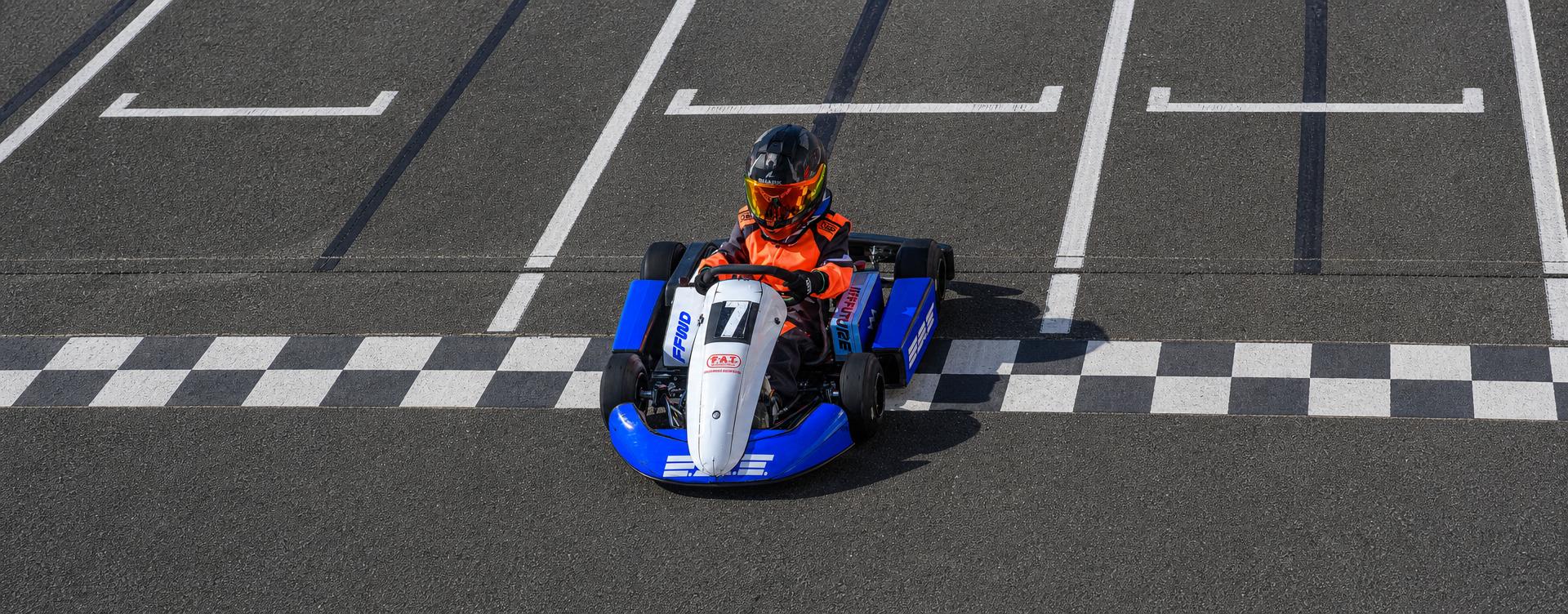 Young drivers racing FAT Karting League karts through a corner